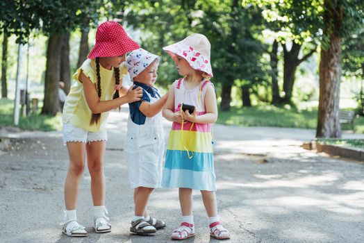 Cute girl and boy listening to music through headphones on the street.