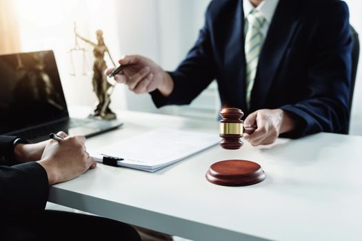 Focus at gavel, Attorney or Lawyer holding a pen is consulting with a client to explain the pattern of answering questions before going to court to decide a lawsuit