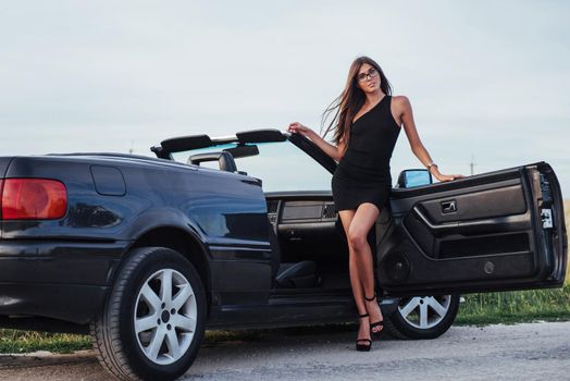 Beautiful woman near black convertible. Ukraine. Europe