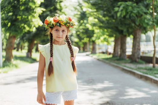 Happy Baby summer. Beautiful girl with a wreath of flowers.