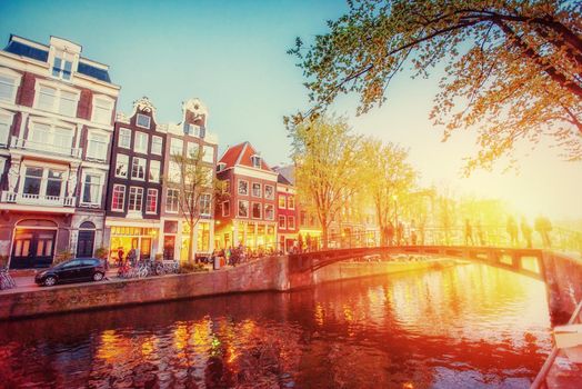 Fantastic sunset that shines on buildings and reflected in the water. Amsterdam is the capital and most populous city in Netherlands.