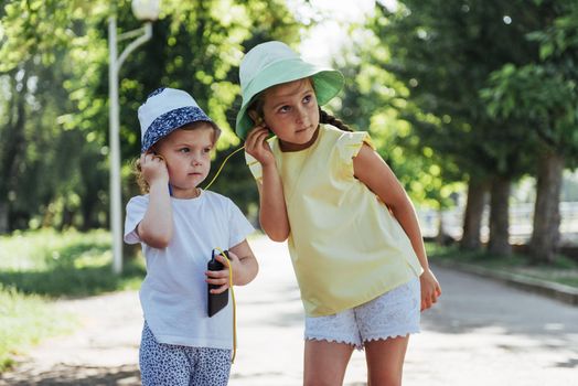 Happy girl with headphones to share music from your smartphone on street