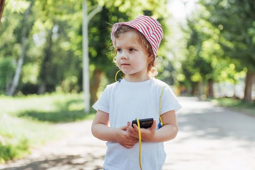 Cute girl listening to music with headphones outdoors.