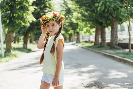 Happy Baby summer. Beautiful girl with a wreath of flowers.