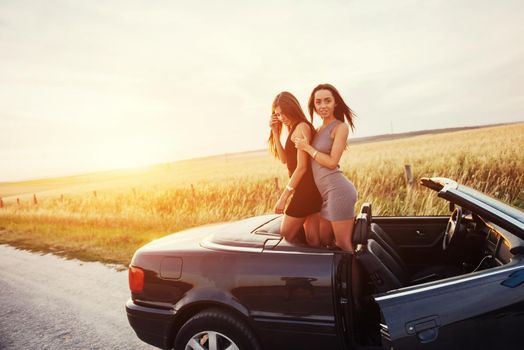 Two women in a black car on the roadside roads.