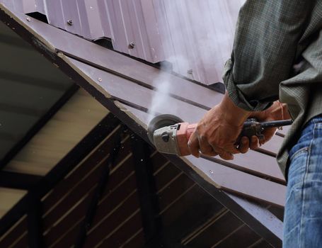 worker use small grinding tool for cutting wood construction 