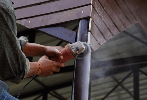 worker use small grinding tool for cutting wood construction 