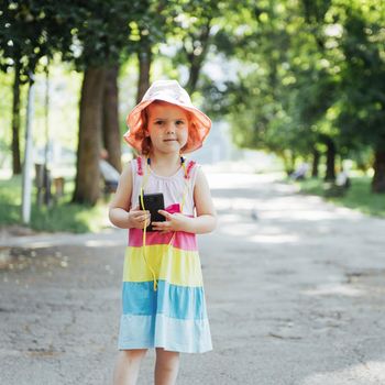 Cute girl listening to music with headphones outdoors.