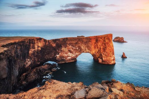 Cape Dyrholaey at southern Iceland. Altitude 120 m, and mean hill island with a door opening.