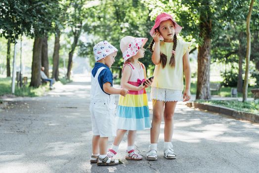 Cute girl and boy listening to music through headphones on the street.