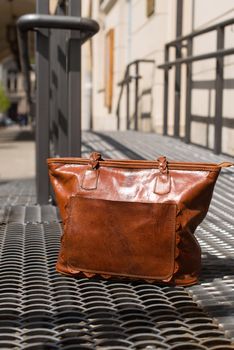 close-up photo of orange leather bag on a metal texture background. outdoor photo