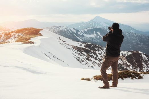 tourist looks at the landscape. Photographer on top of mountain. Spring landscape. Carpathians Ukraine Europe