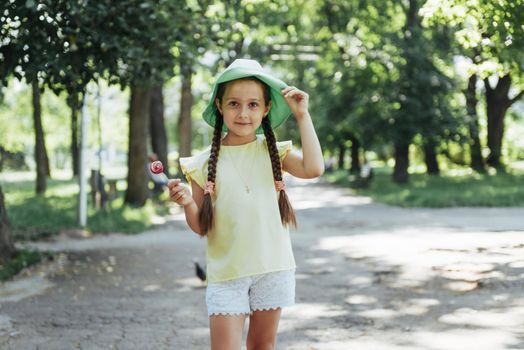 Funny child with candy lollipop, happy little girl eating big sugar lollipop, kid eat sweets.