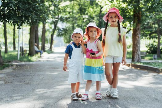 Cute girl and boy listening to music through headphones on the street.