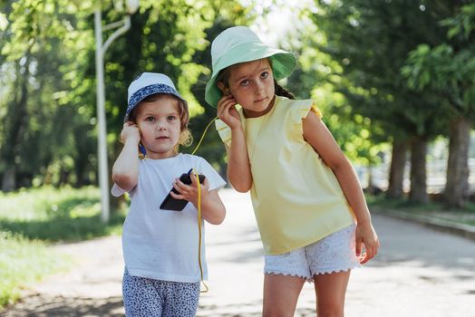 Happy girl with headphones to share music from your smartphone on street