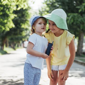 Happy girl with headphones to share music from your smartphone on street