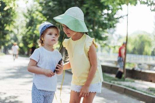 Happy girl with headphones to share music from your smartphone on street
