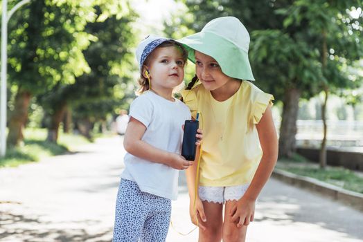 Happy girl with headphones to share music from your smartphone on street