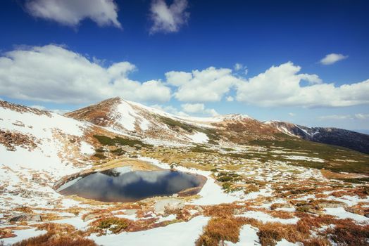 Mountain Lake. Reflection of sky in water. Spring landscape. Carpathians Ukraine Europe