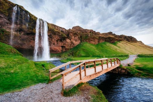 Seljalandfoss waterfall at sunset. Bridge over the river. Fantastic nature. Iceland. Europe