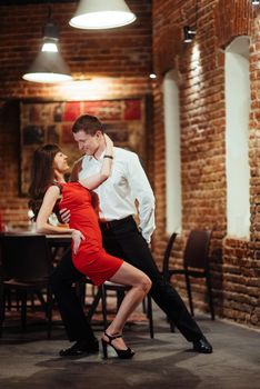 Dancing young couple on a white background. Passionate salsa dancers
