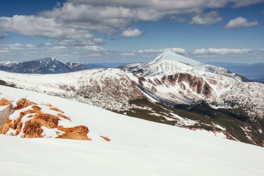 Spring mountain landscape. Snowy Mountains. Beautiful cumulus clouds. Carpathians Ukrain Europe