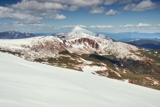 Spring mountain landscape. Snowy Mountains. Beautiful cumulus clouds. Carpathians Ukrain Europe