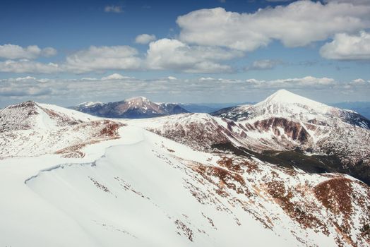 Spring mountain landscape. Snowy Mountains. Beautiful cumulus clouds. Carpathians Ukrain Europe