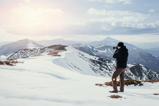tourist looks at the landscape. Photographer on top of mountain. Spring landscape. Carpathians Ukraine Europe