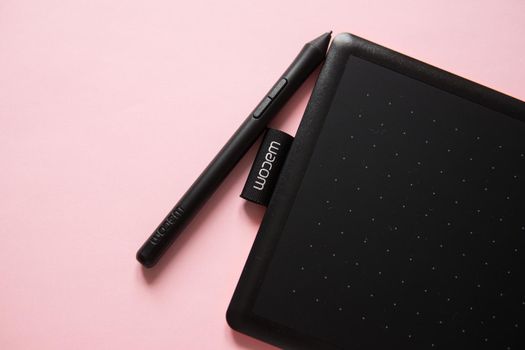 Tver, Russia - February 3, 2020 Top view of Wacom graphic tablet on pink background. Space for text. Selective focus.
