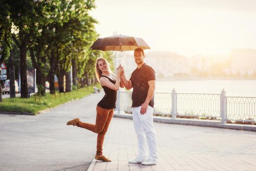 Guy and the girl under an umbrella.