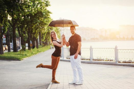 Guy and the girl under an umbrella.