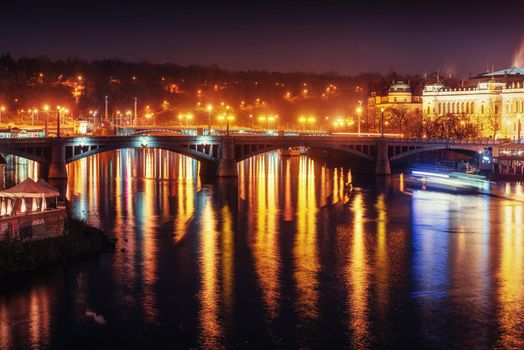 The magnificent Prague Castle at night along the River Vltava.