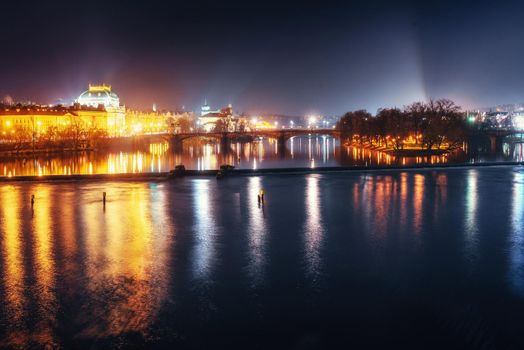 Scenic view of bridges on the Vltava river and of the historical center of Prague: buildings and landmarks of old town with red rooftops.