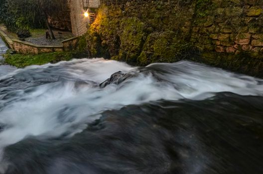 white stream waterfall flowing in dark green forests at night long exposure shot image is taken at trillo waterfall, castilla la mancha