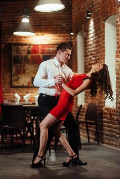 Dancing young couple on a white background. Passionate salsa