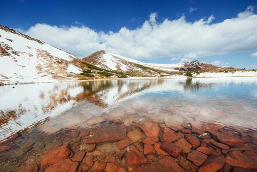 Lake between mountains. Spring landscape. Carpathians Ukraine Europe