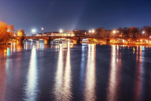 Scenic view of bridges on the Vltava river and of the historical center of Prague: buildings and landmarks of old town with red rooftops.