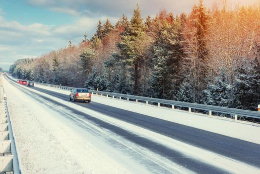Winter road through snowy fields and forests.