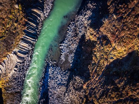 Top view of bright green river and basaltic canyon