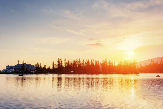 The sunrise over a lake in the park High Tatras. Shtrbske Pleso, Slovakia, Europe.
