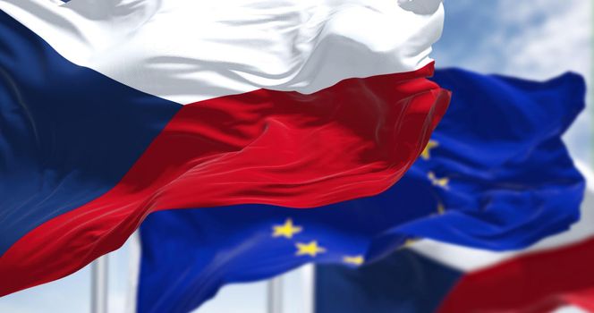 Detail of the national flag of Czech Republic waving in the wind with blurred european union flag in the background on a clear day. Democracy and politics. European country. Selective focus.