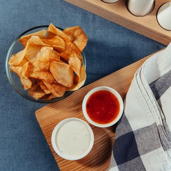 Potato chips with sauce on the table. Homemade sauces.