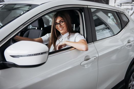attractive young Caucasian woman looking at the camera from the front seat of the car