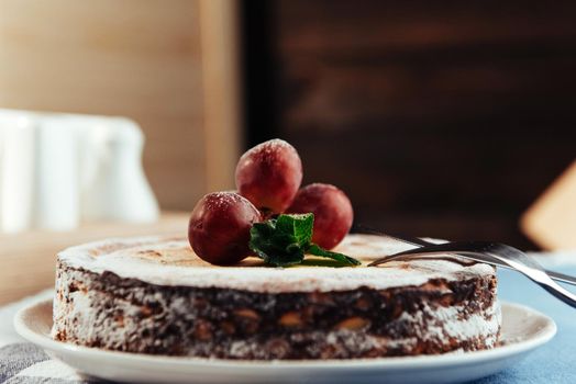 Fresh Creamy traditional cheesecake with grapes and sprinkled with powdered sugar.