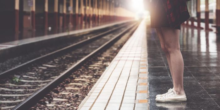 Pretty Young traveler woman planning trip at train station. Summer and travel lifestyle concept