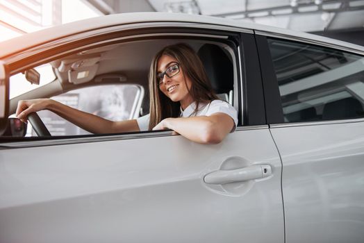 attractive young Caucasian woman looking at the camera from the front seat of the car