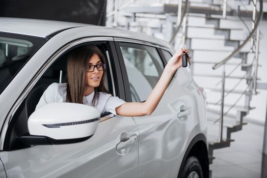 The woman driver smiling showing new car keys.