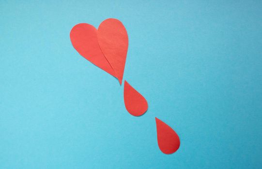 The concept of the World Blood Donor and Hemophilia Day. Red paper drops of blood on a blue background.