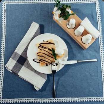 delicious pancakes with chocolate syrup and ice cream and a sprig of mint